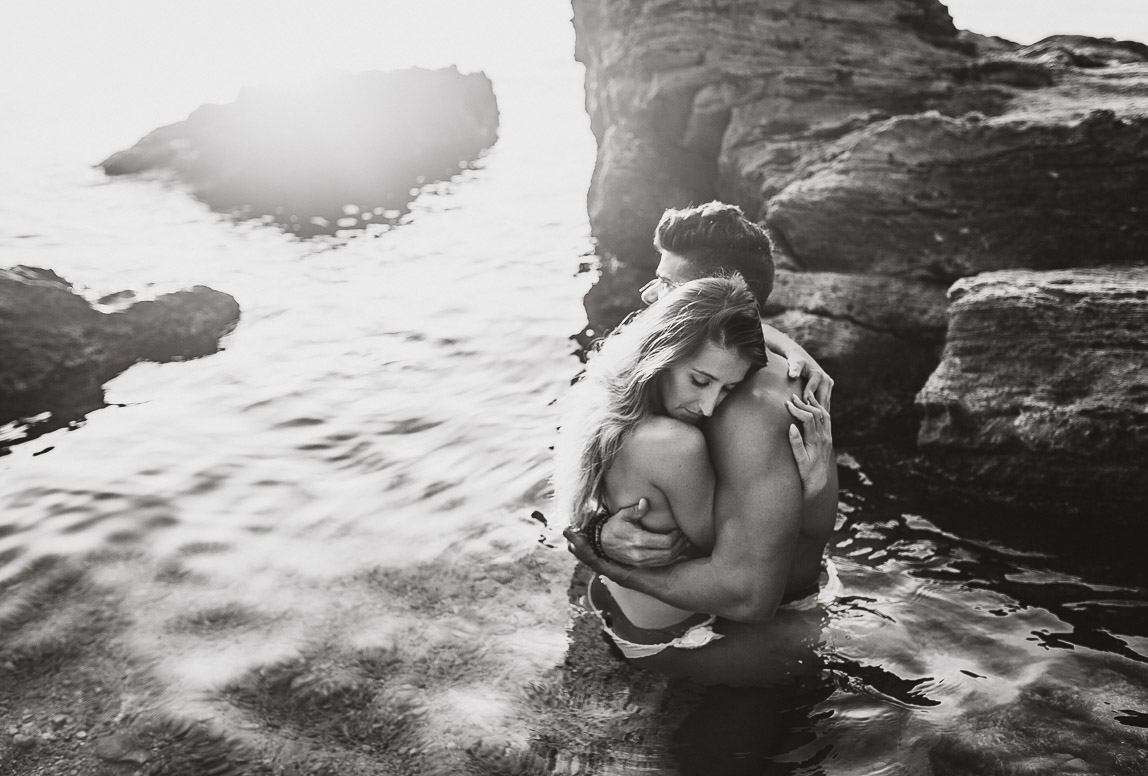 couple beach photography mallorca - intimate black and white photo of couple hugging in the water
