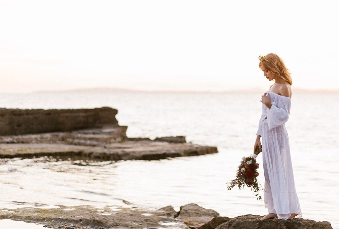 mallorca after wedding photography - a bride holding a bouquet by the beach