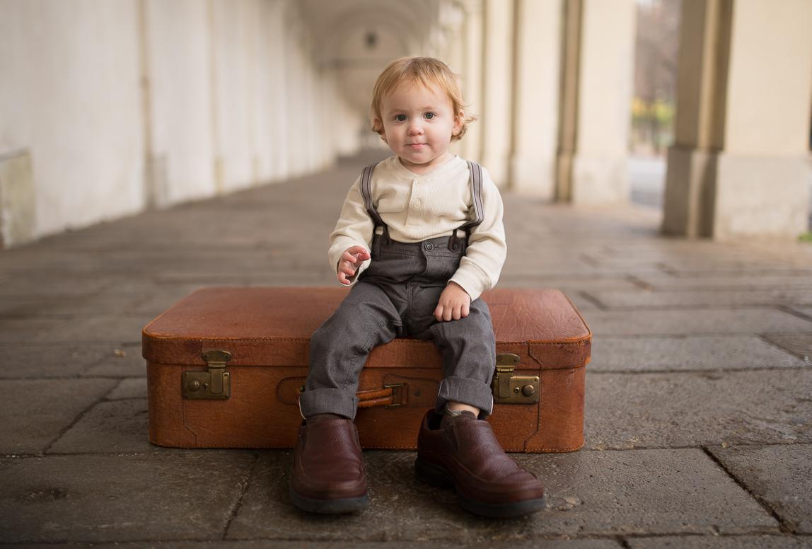 mallorca baby photography - a cute baby sitting on a luggage