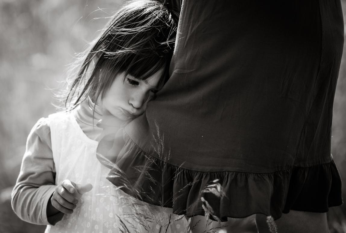 mallorca cute children portraits - shy little girl hiding behind a skirt