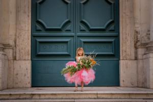 mallorca kids portrait photography - a cute little girl in a tutu dress holding a big bouquet of flowers
