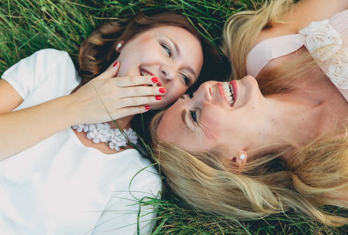 artistic portrait photo session mallorca - women laughing while laying on the grass