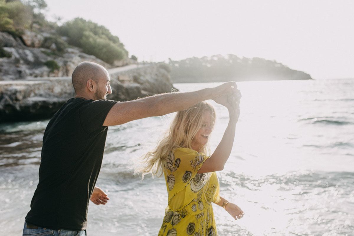 playful couple at the beach by engagement photographer