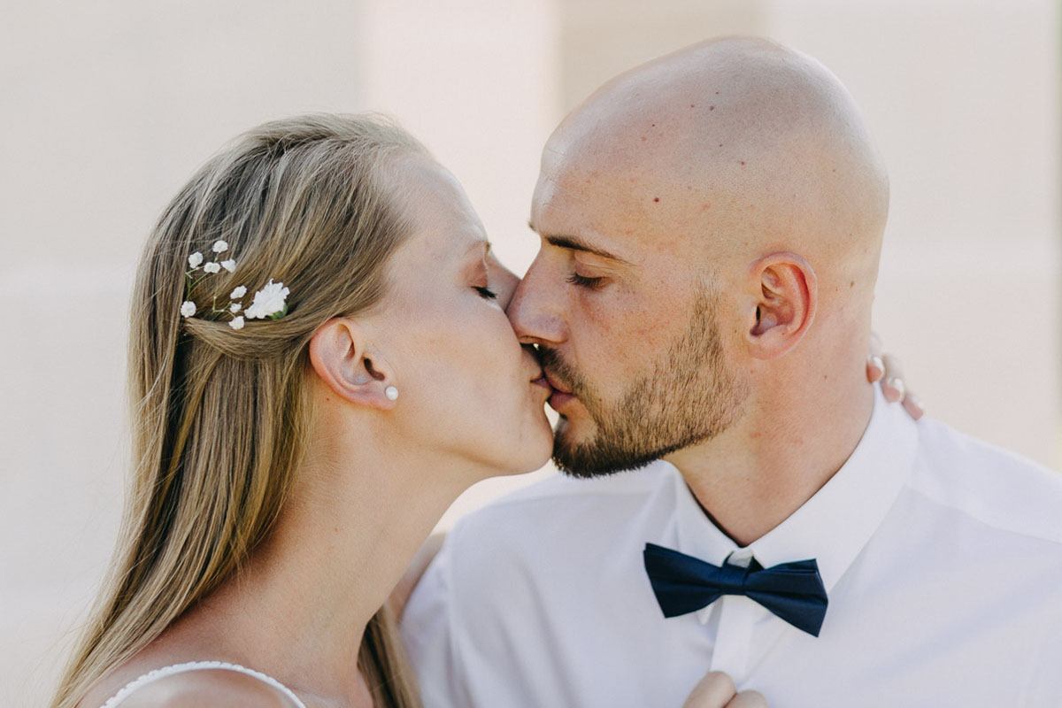 mallorca casual wedding photographer bride and groom share a kiss by the fountain