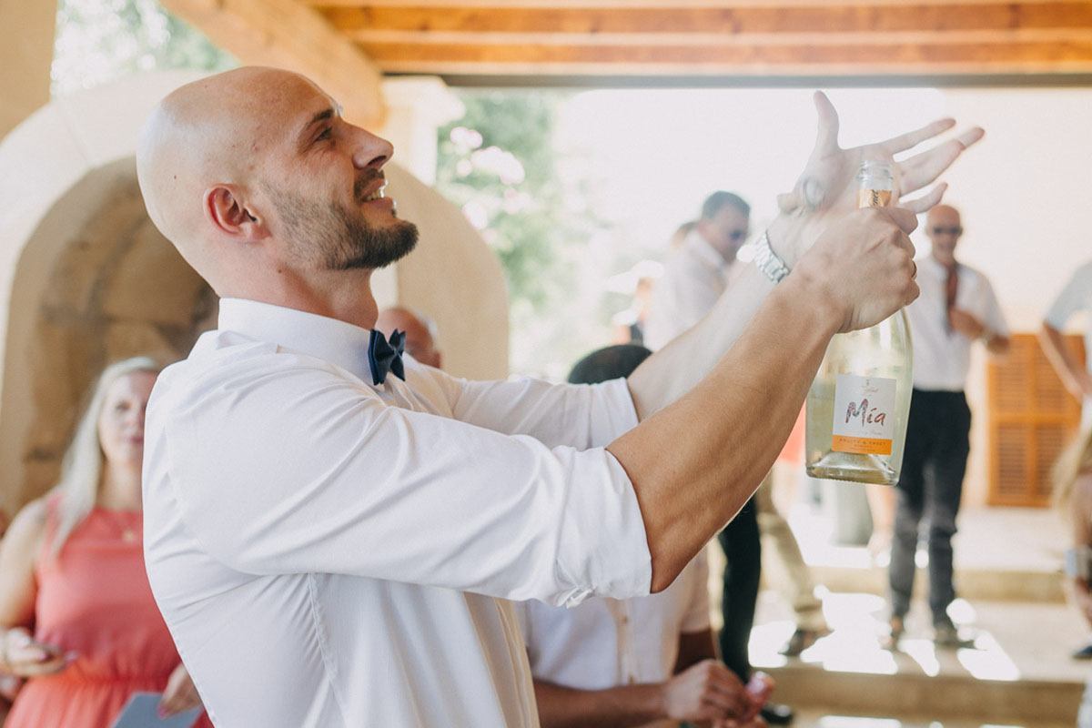 photographer in Mallorca - the groom celebrates with champagne