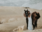 Adventure Wedding photographer - bride with horse in desert during destination wedding in south america