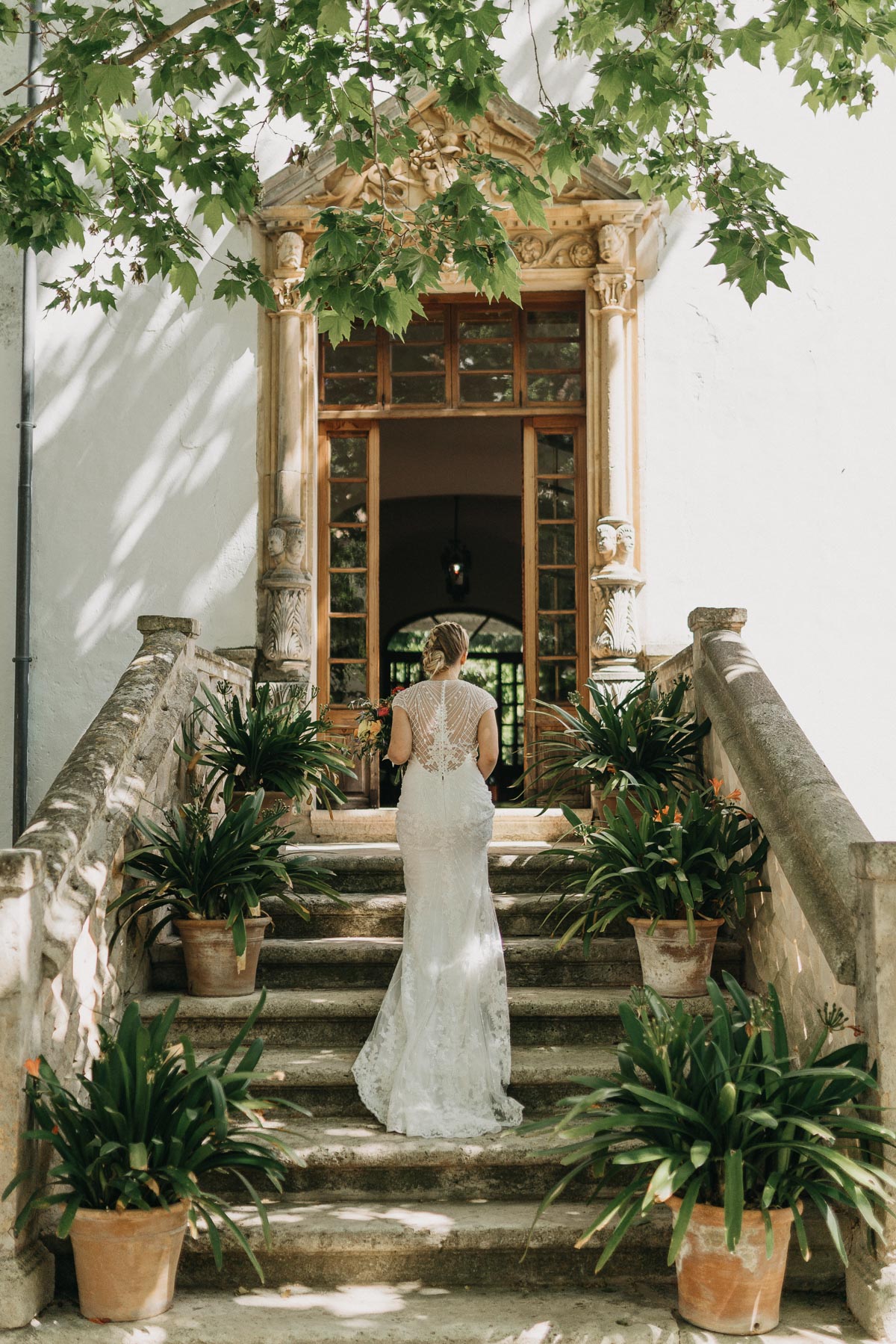 Deia wedding photographer Romany Flower captures bride walking up stairs at Jardines de Alfabia wedding